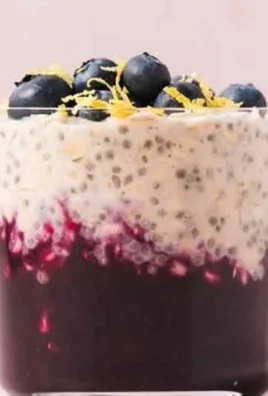 Bowl of blueberry lemon overnight oats garnished with fresh blueberries and lemon zest
