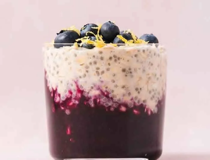 Bowl of blueberry lemon overnight oats garnished with fresh blueberries and lemon zest