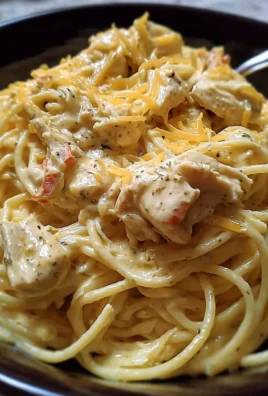 Crockpot Cheesy Chicken Spaghetti served in a bowl with herbs on top