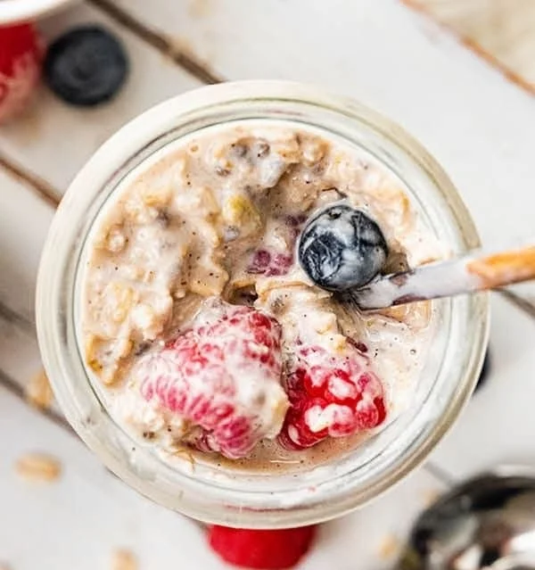 Bowl of low calorie overnight oats topped with fresh fruits and nuts