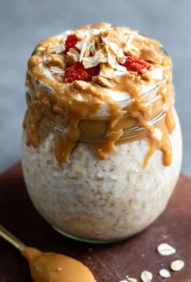 Bowl of Peanut Butter Cheesecake Overnight Oats topped with nuts and chocolate