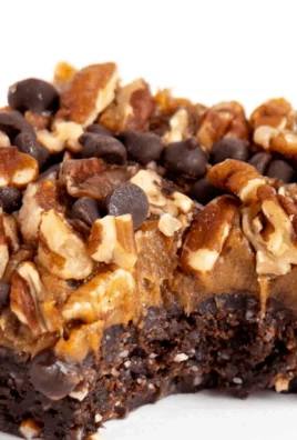 Vegan gluten-free turtle brownies in a decorative dish with a drizzle of chocolate.