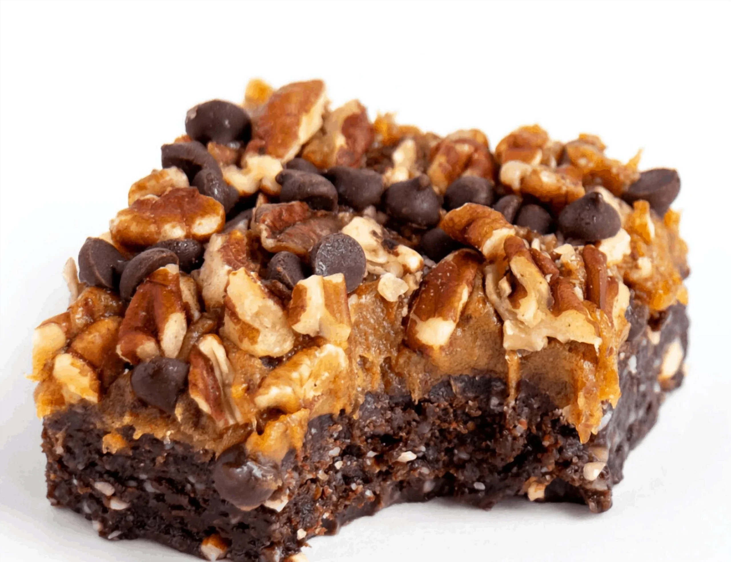 Vegan gluten-free turtle brownies in a decorative dish with a drizzle of chocolate.