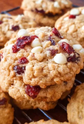 Plate of homemade white chocolate cranberry oatmeal cookies with a glass of milk